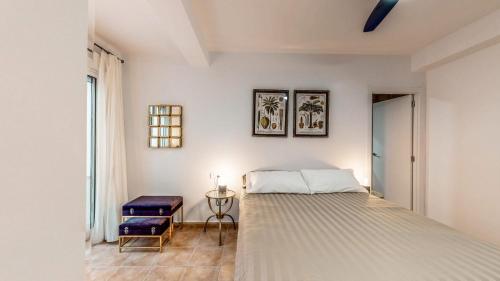a white bedroom with a bed and a window at HoliSPlace- lovely apartment in downtown Alicante in Alicante
