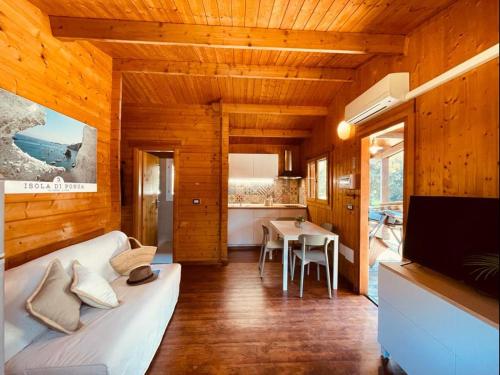 ein Wohnzimmer mit einem weißen Sofa und einem TV in der Unterkunft Le Dune Villaggio in Lido Di Fondi