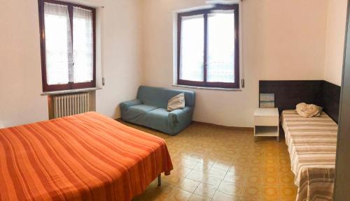een slaapkamer met een bed, een bank en een stoel bij Homiday - Parco della Pace in Pineto