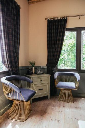 two chairs sitting in a room with a window at AMAYA HOME - Lodge, Spa & Restaurant in Hanoi