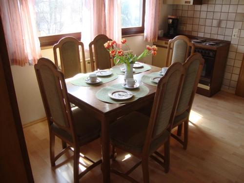 a dining room table and chairs with flowers on it at Haus Reif in Dombühl