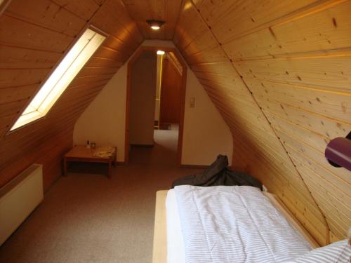 a room with a bed in a wooden attic at Haus Reif in Dombühl