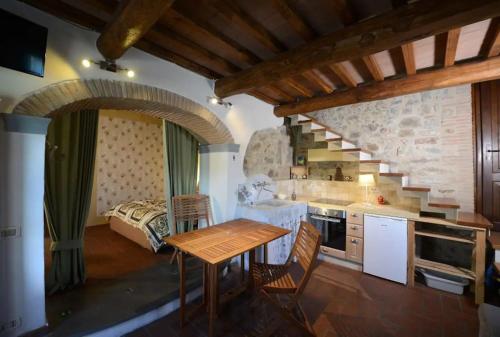 a kitchen with a wooden table in a room at Morelliana4Rooms in Scansano