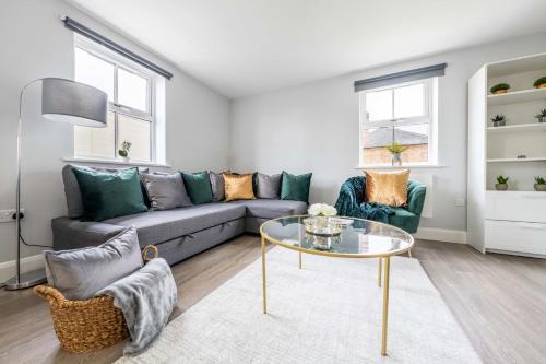 a living room with a couch and a glass table at Super Luxe Central Maidenhead Apartment in Maidenhead