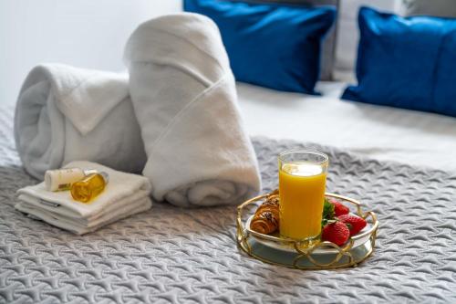 a tray of fruit and a glass of orange juice on a bed at Super Luxe Central Maidenhead Apartment in Maidenhead