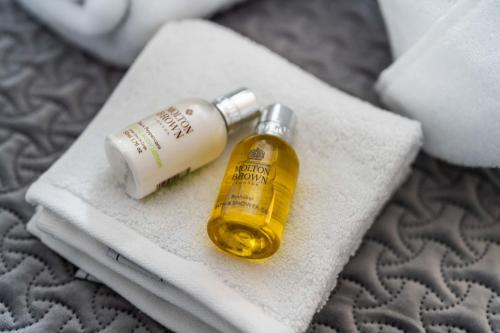 a bottle of essential oil sitting on a towel at Super Luxe Central Maidenhead Apartment in Maidenhead