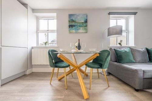 a dining room with a table and green chairs at Super Luxe Central Maidenhead Apartment in Maidenhead