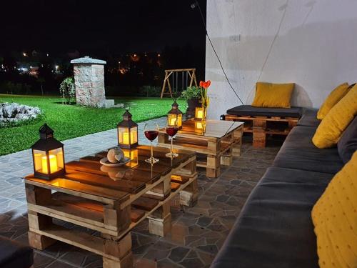 a patio with a couch and a table with wine glasses at Rtanjska bajka in Boljevac
