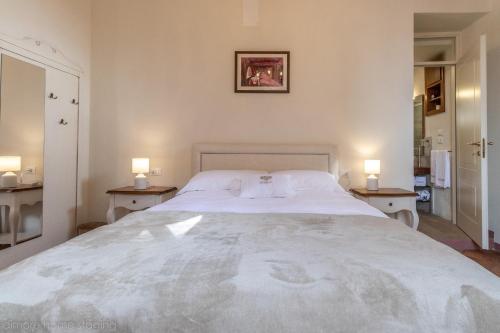 a bedroom with a large white bed with two night stands at Casa Maghinardo in Brisighella