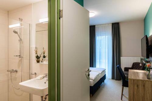a bathroom with a sink and a bed in a room at Nutzwedel Resort Farmers Lodge in Horst in Holstein