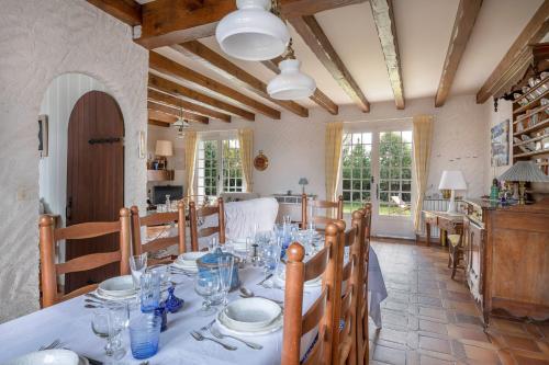 une salle à manger avec une table, des assiettes et des verres dans l'établissement Tous à la mer dans une grande maison de famille !, à La Plaine-sur-Mer