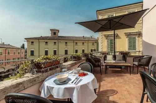a table and chairs on a balcony with a view of a building at Casa Maghinardo in Brisighella