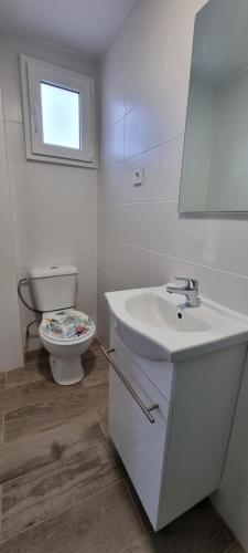 a bathroom with a white sink and a toilet at Hostal La Cabaña in Salou