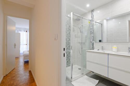 une salle de bain blanche avec une douche et un lavabo dans l'établissement Un été sans fin, à Marseille