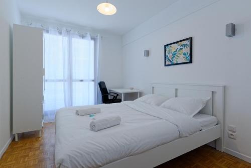 - un lit blanc avec 2 serviettes dans une chambre dans l'établissement Un été sans fin, à Marseille