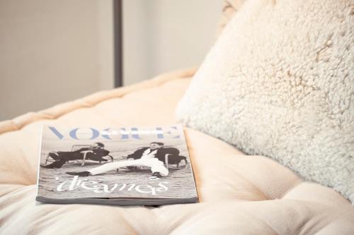 a magazine sitting on top of a bed at Appartementen Zer en Loft in centrum Bergen in Bergen