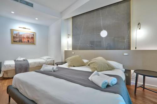 a hotel room with two beds and two tables at belMORO - La Dimora Del Capo in Palermo