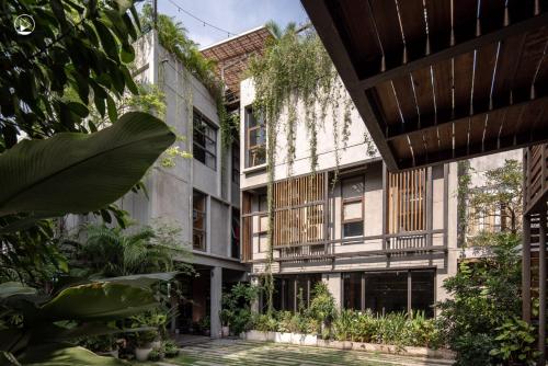 una vista externa de un edificio con plantas en Tamni en Bangkok