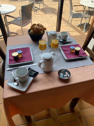 een tafel met twee borden eten en twee glazen sinaasappelsap bij Auberge Coralli in Sartène