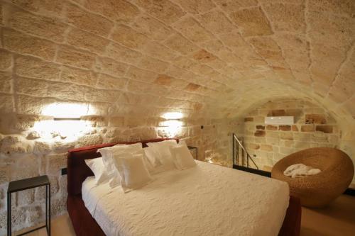 een slaapkamer met een bed in een stenen muur bij SUITE & SPA VIA VENETO in Monopoli