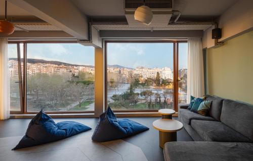 a living room with a couch and a large window at Zeus is Loose in Thessaloniki