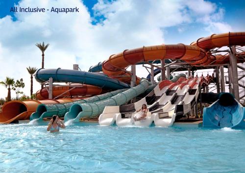 - un toboggan aquatique dans un parc d'attractions avec des personnes dans l'eau dans l'établissement Valeria Madina Club - All Inclusive, à Marrakech