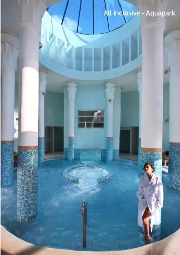 a woman sitting in the water in a pool at Valeria Madina Club - All Inclusive in Marrakech