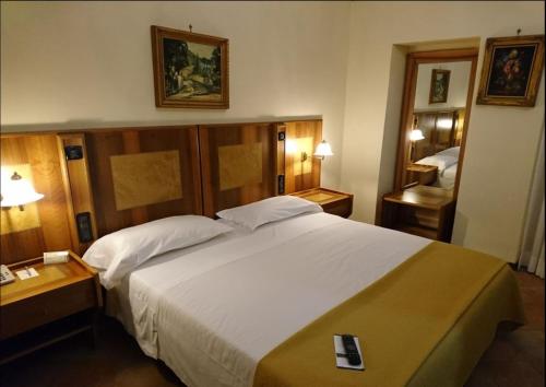 a bedroom with a large white bed and two lamps at Villa Tuscolana in Frascati