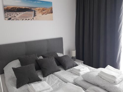 a bedroom with a bed with towels on it at Rewal Resort Klifowa - Morska 3/12 in Rewal