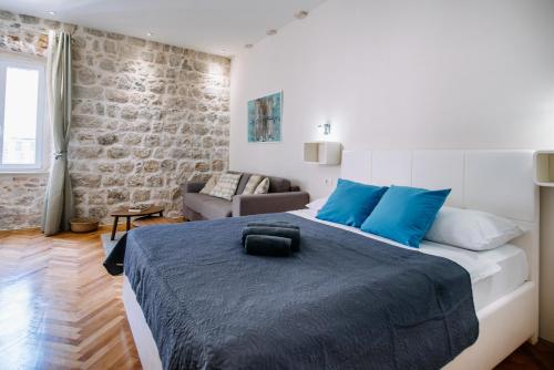a bedroom with a large bed and a couch at AMOROZO APARTMENTS by DuHomes in Dubrovnik