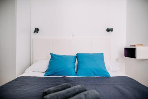 a bedroom with a bed with blue pillows at AMOROZO APARTMENTS by DuHomes in Dubrovnik