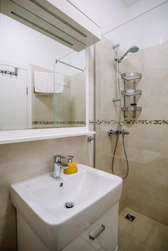 a bathroom with a white sink and a shower at AMOROZO APARTMENTS by DuHomes in Dubrovnik