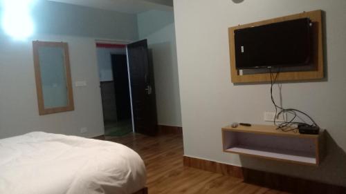 培靈的住宿－Mandavya homestay，一间卧室配有一张床和一台平面电视