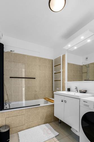 une salle de bain blanche avec une baignoire et un lavabo dans l'établissement Disneyland-Paris 8pers,Parking, borne recharge VE, Wifi, à Serris