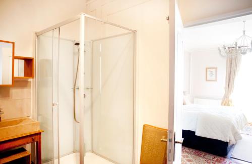 a glass shower in a bedroom with a bed at Maison Bellachonne in Bellac