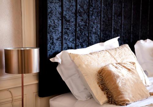 a pillow sitting on a bed next to a lamp at Maison Bellachonne in Bellac