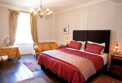 a bedroom with a large bed and a chandelier at Maison Bellachonne in Bellac