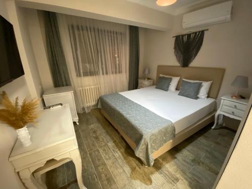 Un dormitorio con una gran cama blanca y una ventana en Kale Motel, en Gokceada Town