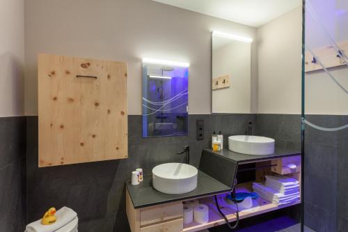 a bathroom with two sinks and a glass shower at Familienhotel Huber in Valles