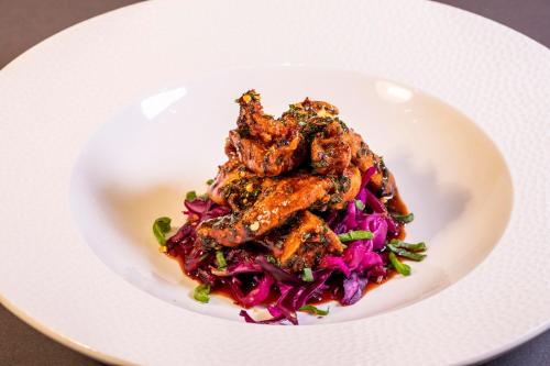a plate of food with chicken wings and purple cabbage at Hillyard House Hotel in Castlewellan
