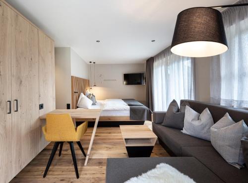 a living room with a couch and a bed at Familienhotel Huber in Valles