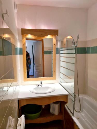 une salle de bain avec un lavabo, un miroir et une baignoire dans l'établissement Appartement chaleureux à Chamrousse, 42 m², parking inclus, à Chamrousse