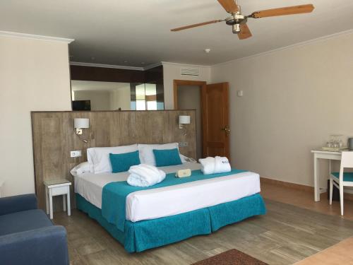 1 dormitorio con 1 cama grande con almohadas azules y blancas en Playasol Aquapark & Spa Hotel, en Roquetas de Mar