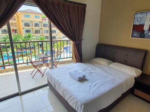 a bed in a bedroom with a view of a balcony at Gold Coast Morib Themepark View Studio in Banting