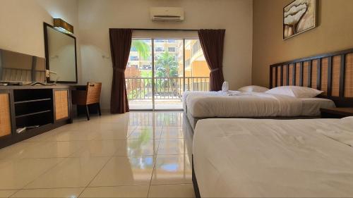 a hotel room with two beds and a balcony at Gold Coast Morib Themepark View Studio in Banting