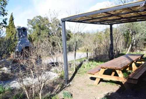 a picnic table under a shelter in a field at Maison accueillante, Les Vans, vue sur montagne, grand jardin in Les Vans