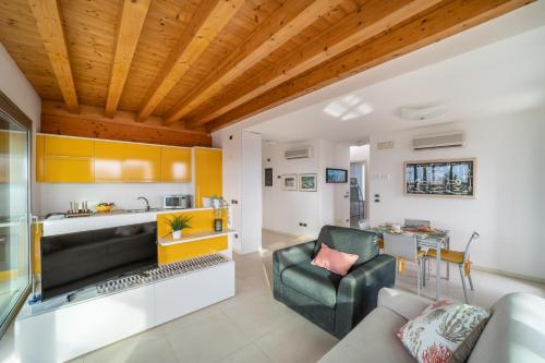 a living room with a couch and a kitchen at Residenza Ore Felici in Lignano Sabbiadoro