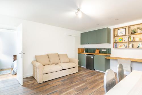 a living room with a couch and a kitchen at Suite in Suresnes