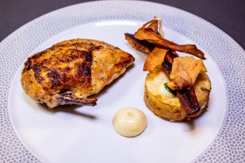 a white plate with a chicken and french fries at Hillyard House Hotel in Castlewellan