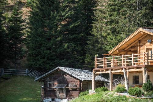 a log cabin with a deck on the side of it at Familienhotel Huber in Valles